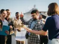 Une équipe célèbre sa journée du personnel avec joie. Un homme danse, d'autres sourient, certains tiennent des documents.