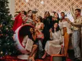 Ambiance festive pour une soirée de Noël entreprise : un groupe d'amis pétillants trinque près d'un sapin décoré, dans une atmosphère rétro et joyeuse.