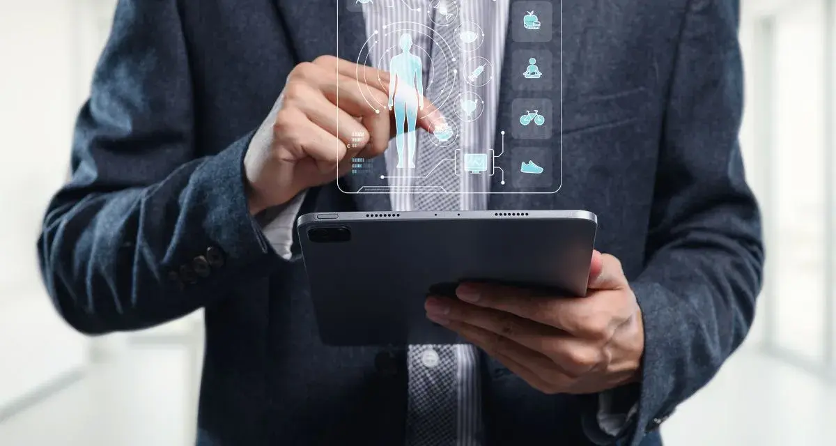 Un homme en costume utilise une tablette pour visualiser un tableau de bord de santé, marquant la cloture de projet.