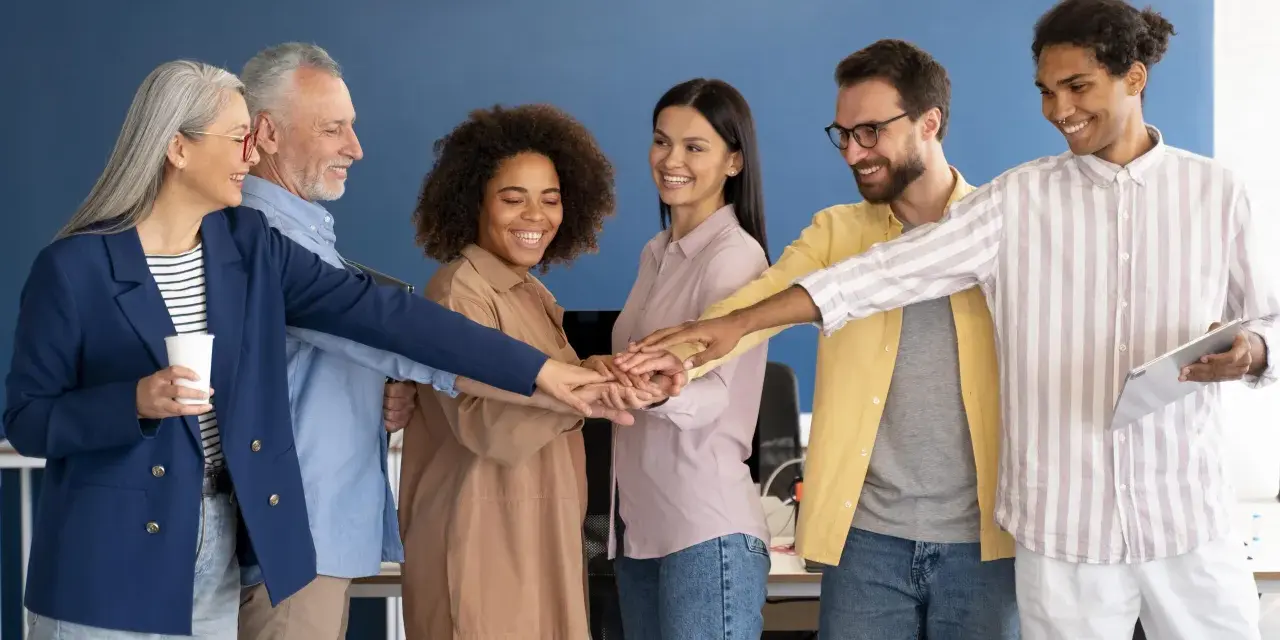 Une équipe soudée lance un défi entre collègues, mains jointes pour la victoire.