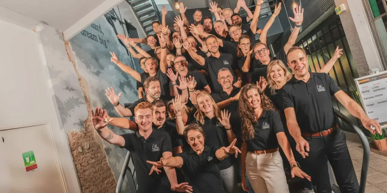 Une équipe souriante et joyeuse, unie pour un moment de **team building gratuit**. Ils montent les escaliers, bras levés, prêts à relever de nouveaux défis.