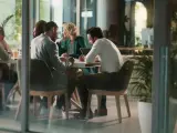Des employés discutent autour d'une table, mais chacun semble travailler dans son coin, comme s'ils étaient en train de travailler en silo.