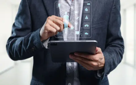 Un homme en costume utilise une tablette pour visualiser un tableau de bord de santé, marquant la cloture de projet.