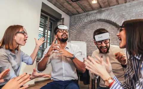 Des employés s'amusent lors d'un jeu d'entreprise exemple, devinant des mots inscrits sur des bandeaux.