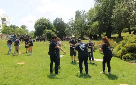 Des personnes participent à une activité de plein air, une idée de challenge sportif, en manipulant des cordes et des structures en bois.