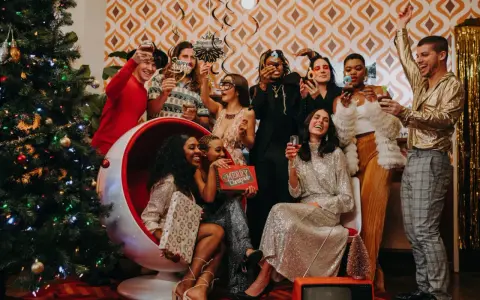 Ambiance festive pour une soirée de Noël entreprise : un groupe d'amis pétillants trinque près d'un sapin décoré, dans une atmosphère rétro et joyeuse.