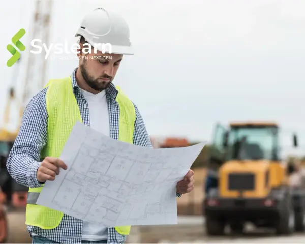 Un chef de projet AMOA, casque blanc et gilet fluo, examine des plans sur un chantier.