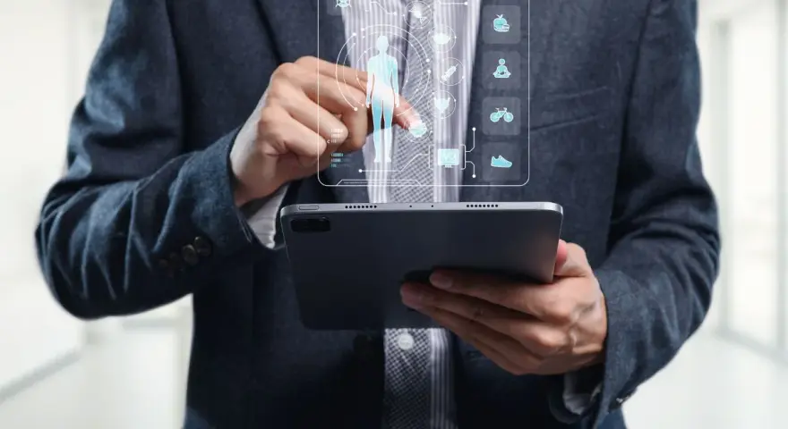 Un homme en costume utilise une tablette pour visualiser un tableau de bord de santé, marquant la cloture de projet.
