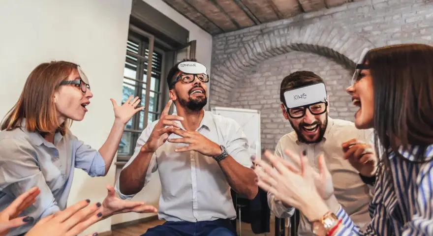 Des employés s'amusent lors d'un jeu d'entreprise exemple, devinant des mots inscrits sur des bandeaux.