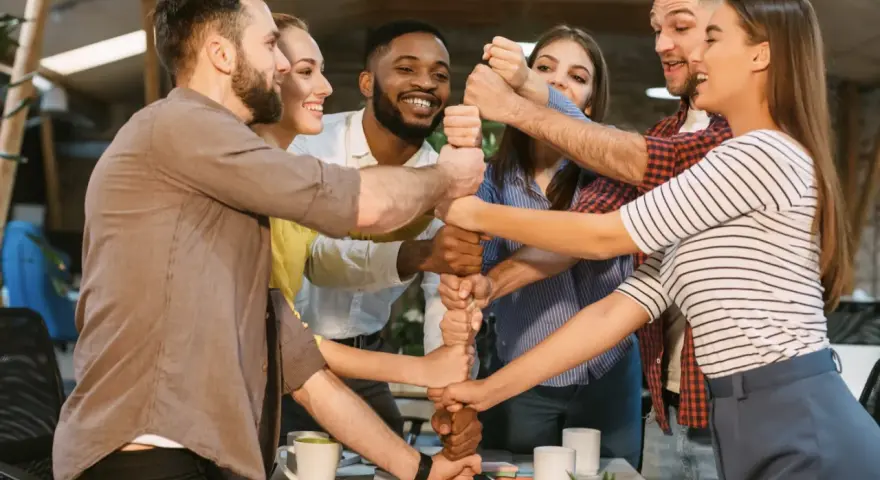 Une équipe soudée, poings serrés, symbolisant l'unité et la collaboration. Une belle idée séminaire pour renforcer la cohésion.