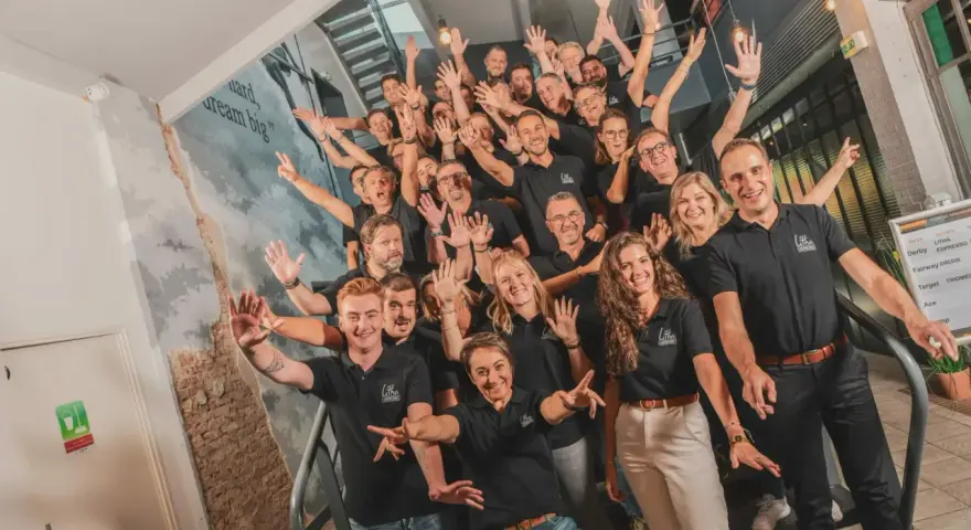 Une équipe souriante et joyeuse, unie pour un moment de **team building gratuit**. Ils montent les escaliers, bras levés, prêts à relever de nouveaux défis.