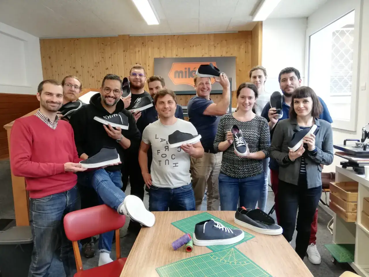 L'&eacute;quipe c&eacute;l&egrave;bre sa journ&eacute;e du personnel en montrant fi&egrave;rement les chaussures qu'ils ont fabriqu&eacute;es.